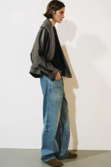 Jeans de tiro bajo y diseño wide leg de la colección ZW Collection de Zara, con efecto lavado, cinco bolsillos, trabillas en la cintura y cierre frontal con cremallera y botón metálico.