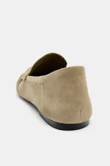 Mocasín plano de mujer en gamuza color beige, estilo driving moc, con detalle de fruncidos y costuras decorativas en la puntera y tira de antifaz.