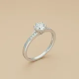 Anillo de plata 925 con piedra central de circonia engarzada en seis puntas y banda delgada.