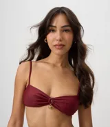Top de bikini bandeau de microfibra color bordó, con fruncido delantero, tirantes finos regulables y un dije metálico dorado en el centro.