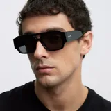 Lentes de sol con diseño oversized de estilo aviador con doble puente y frontal flat-top. Montura negra con lentes polarizadas oscuras.