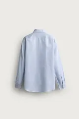 Camisa negra de corte regular fit, cuello italiano, manga larga con puño abotonado y cierre frontal con botones.