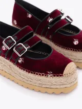 Zapato tipo Mary Jane de terciopelo bordó con estampado floral, doble tira con hebillas metálicas en el empeine y plataforma de yute con suela dentada.
