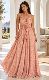 Vestido largo rosado con escote en V halter, tirantes finos y falda fluida amplia. Presenta bordados artesanales a mano con detalles brillantes en toda la prenda y cordón frontal ajustable con borlas.