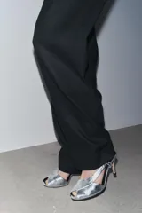 Sandalias plateadas de piel metalizada con puntera abierta, tiras cruzadas y cierre con tira trasera elástica. Tacón fino de 9,5 cm.