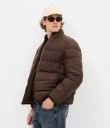 Campera masculina de microfibra ultraligera, con diseño acolchado, cuello alto y cierre frontal por cremallera. Cuenta con bolsillos laterales y acabado liso.