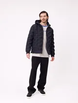 Campera puffer con capucha, color verde militar, con cierre frontal y bolsillos laterales. Presenta un diseño acolchado con costuras termoselladas y puños elásticos.