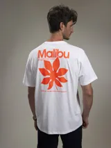 Remera blanca de algodón con estampado trasero en color naranja que incluye la palabra "Malibu", una hoja de palma y texto adicional.