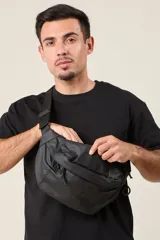 Riñonera negra de tela impermeable con correa ajustable con hebilla.