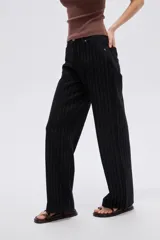 Pantalón jean negro de tiro alto con diseño a rayas y corte baggy de pernera ancha.