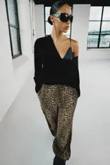 Pantalón bombacho de tiro medio con estampado animal print, bolsillos delanteros, bajo con puño y cierre frontal con cremallera y gancho metálico.