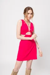 Vestido corto fucsia con escote en V y corte a la cintura. Presenta aberturas laterales y lazo ajustable en la espalda.