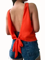 Blusa rosa sin mangas con espalda descubierta y lazo en la cintura.