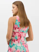 Vestido largo de chifón con estampado floral en tonos rosa y turquesa. Presenta cuello halter con abertura tipo lágrima, cintura drapeada con detalle de nudo central y falda amplia con capas asimétricas. Incluye forro interior y cierre invisible en la espalda.