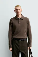 Polo de manga larga con corte regular fit, confeccionado en tejido de algodón con acabado cepillado. Presenta cuello solapa y cierre frontal con botonadura.
