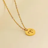 Collar dorado con dije redondo con el signo de Aries grabado.