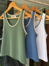 Musculosa de morley verde militar con escote redondo y detalles de bordado artesanal en crochet en los bordes.