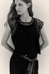 Remera de corte holgado confeccionada en jersey de algodón grueso, con detalles en microtul bordado con lentejuelas en el cuello y las mangas.