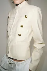 Chaqueta estilo militar ZW Collection confeccionada en hilatura con mezcla de algodón, color crudo, con cuello subido, manga larga, falsos bolsillos de vivo y cierre frontal con ganchos metálicos y botones decorativos dorados.