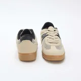 Zapatillas urbanas de malla y ante sintético en tonos beige y negro, con suela de goma marrón y cordones claros.