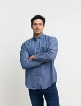 Camisa celeste con microestampado blanco, de corte clásico, manga larga y cuello abotonado. Tiene un bolsillo en el pecho.