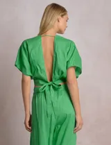Blusa corta cruzada de lino, marca Elan, color azul. Presenta corte crop, escote en V pronunciado, mangas cortas amplias estilo kimono y lazo ancho para anudar en la espalda.