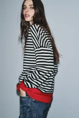 Jersey de lana 100% con rayas horizontales rojas y blancas, cuello redondo y puños y dobladillo en color marrón.