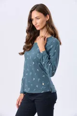 Remera de manga larga con cuello redondo, confeccionada en tejido de algodón estampado con motivos botánicos y aves pequeñas en tonos suaves.