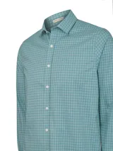 Camisa de manga larga para hombre, color verde azulado (teal) con estampado de cuadros pequeños blancos (gingham). Presenta cuello clásico y bolsillo en el pecho con un pequeño logo bordado.