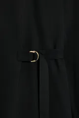 Vestido corto de cuello redondo y manga larga con puños. Presenta un detalle de trabilla con hebilla metálica dorada en la cintura y cierre posterior con abertura y botón.