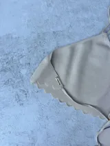 Top de hilo negro tejido de punto, modelo halter, con tiras para atar en la nuca y en la espalda.