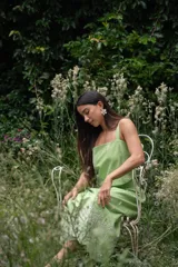 Conjunto de lino color verde claro, compuesto por un crop top con breteles y bordado de flores, y una pollera midi con bordado de flores en el ruedo.