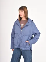 Campera acolchada de color azul, con diseño de costuras en rombos, cierre frontal, capucha y bolsillos delanteros amplios.