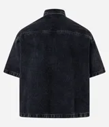 Camisa masculina de jeans negro con lavado marmolado, corte boxy, cuello inglés, manga corta, abotonada al frente y con dos bolsillos de parche en el pecho.
