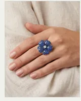 Anillo de plata 925 con diseño de flor, decorado con incrustaciones de piedras azules y un centro brillante.