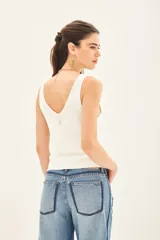 Musculosa de punto compacto color negro, con escote pronunciado y calce al cuerpo.
