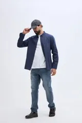 Camisa de twill azul marino con mangas largas, bolsillo en el pecho y botones contrastantes.