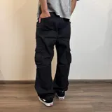 Pantalón jean cargo gris con efecto lavado, corte recto y bolsillos laterales.