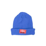 Gorro de lana tipo beanie de color azul, con diseño acanalado y vuelta. Presenta un parche frontal rectangular en color rojo con el logo de Umbro y la inscripción "NACIONAL" en blanco y negro.
