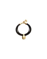 Pulsera de cuero negro con tres tiras, cierre de mosquetón dorado y un dije central en forma de gota, bañado en oro 18K.