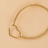 Pulsera de malla metálica con dije central en forma de corazón, ambos en acabado dorado.