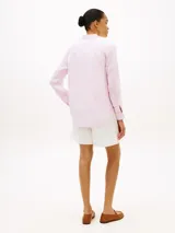 Camisa de corte amplio confeccionada en lino puro, de color rosado. Presenta cuello inglés, cierre frontal de botones, mangas largas con puños abotonados y el logo bordado en el pecho.