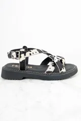 Sandalias con plataforma de cuero con estampado animal print de vaca en blanco y negro.