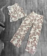 Conjunto de chaleco y pantalón palazzo con estampado floral en tonos beige y marrón.