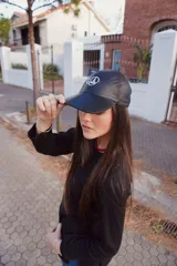 Buzo negro de punto con cuello redondo y logo bordado en el pecho.