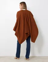 Ruana de tejido soft, color marrón óxido, de corte amplio y sin cierres, con cuello redondo.