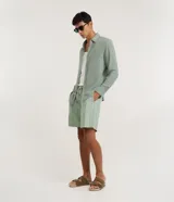 Bermuda de playa para hombre, de corte recto y color verde menta, confeccionada en algodón texturizado con diseño de rayas sutiles. Cuenta con cintura elástica con cordón de ajuste, bolsillos laterales y diseño sin estampas.