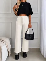 Pantalón de lanilla color beige con sutiles destellos brillantes, de corte recto y holgado. Cuenta con cintura elástica con cordón ajustable.