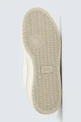 Zapatilla deportiva estilo basket con cordones gruesos, confeccionada en una combinación de piezas en tonos crema y beige, con suela de goma con volumen.