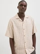 Camisa de manga corta Jack & Jones con cuello resort y cierre de botones. Diseño con estampado geométrico en tonos beige y marrón.